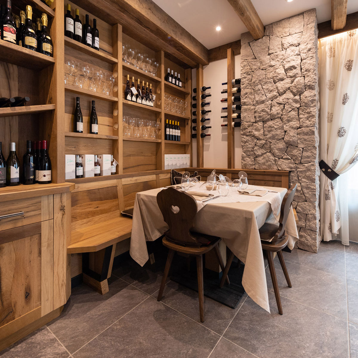 Traditionelle Bauernküche mit Weinregal ,Esstisch und Holzstühlen aus Zirbe