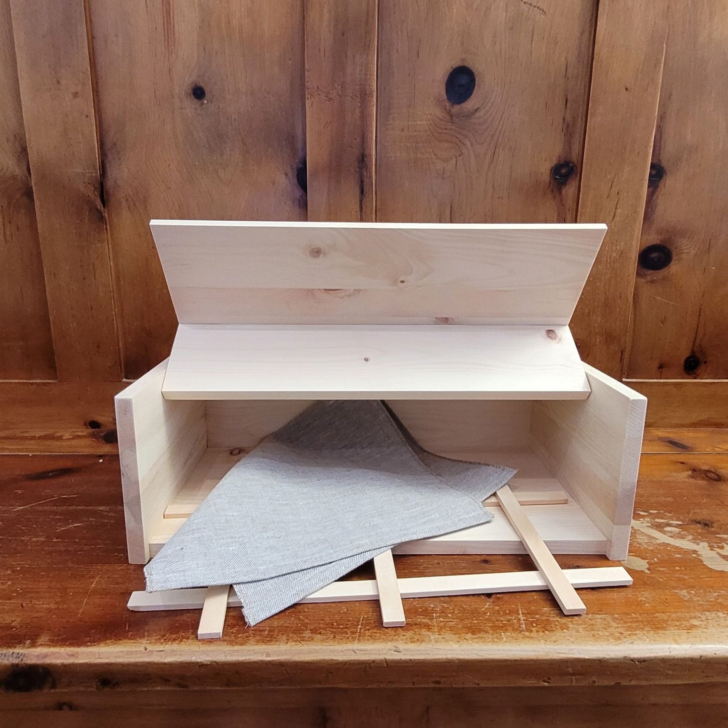 Brotbox aus Zirbenholz für die perfekte Brotaufbewahrung, mit Holzgitter und Leinentuch.