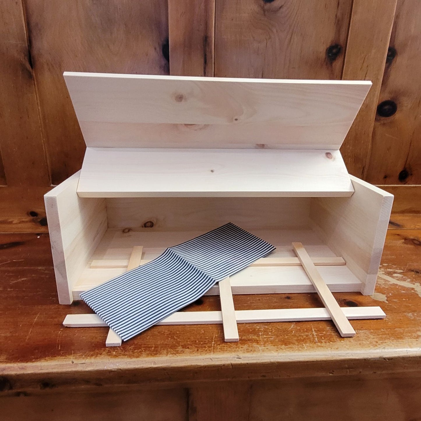 Brotbox aus Zirbenholz für die perfekte Brotaufbewahrung, mit Holzgitter und Leinentuch.