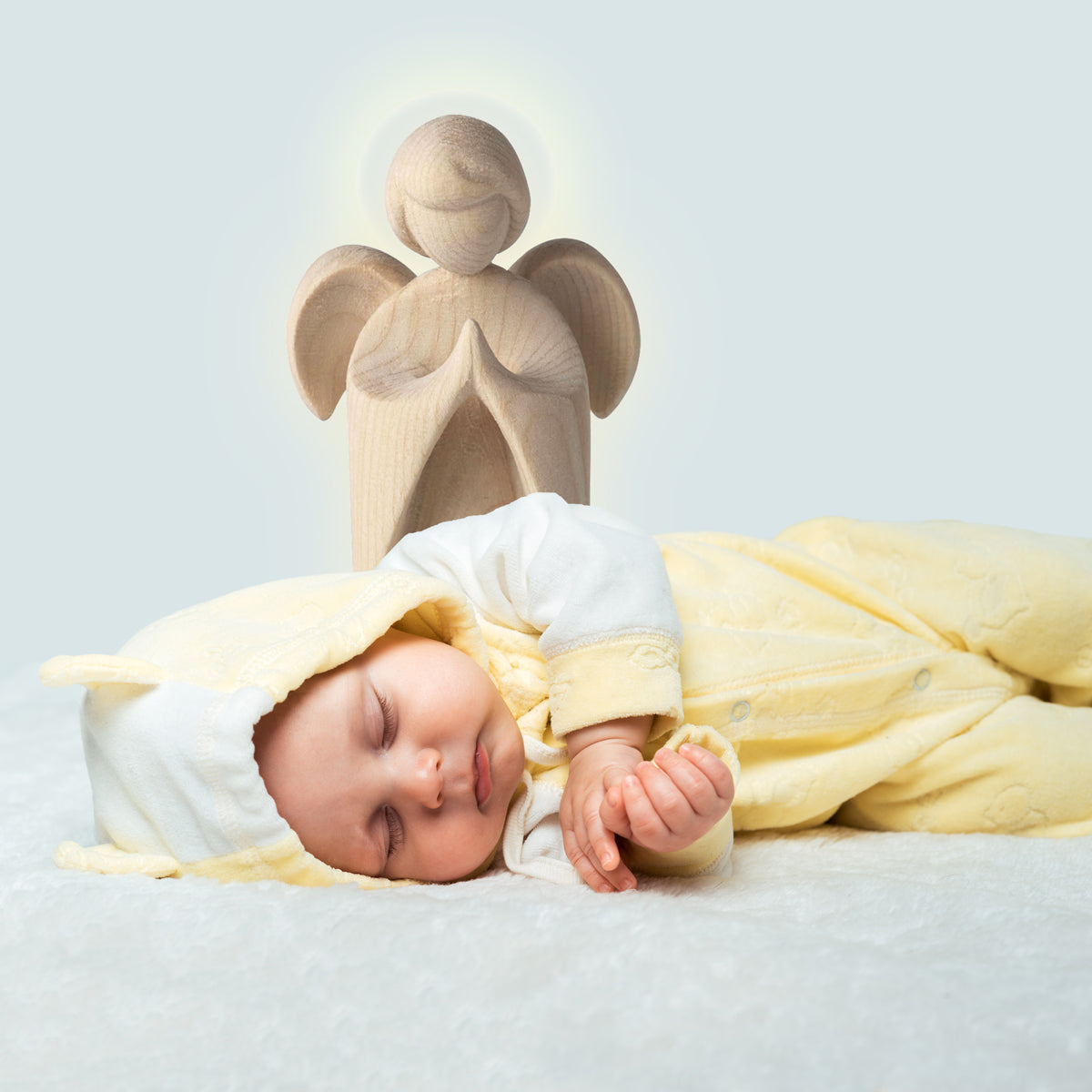 Betender Engel steht hinter Baby