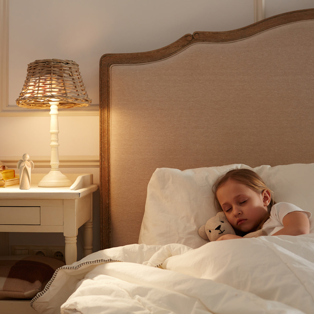 Kind im Bett, auf dem Nachttisch einer der Engel