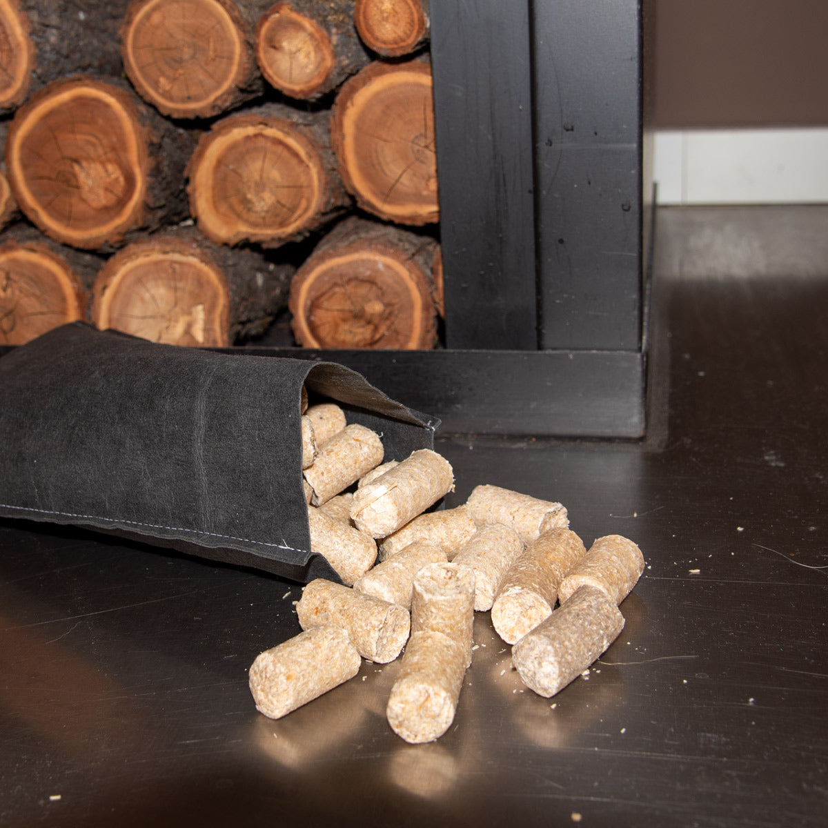 Im Hintergrund Kaminholz gestappelt im Vordergrund das Ledertascherl mit den Anzündern